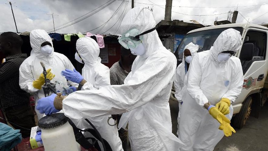 Des membres de la Croix-Rouge se préparent à récupérer le corps d'une victime du virus Ebola, le 4 octobre 2014 dans le quartier de West Point, à Monrovia, au Liberia