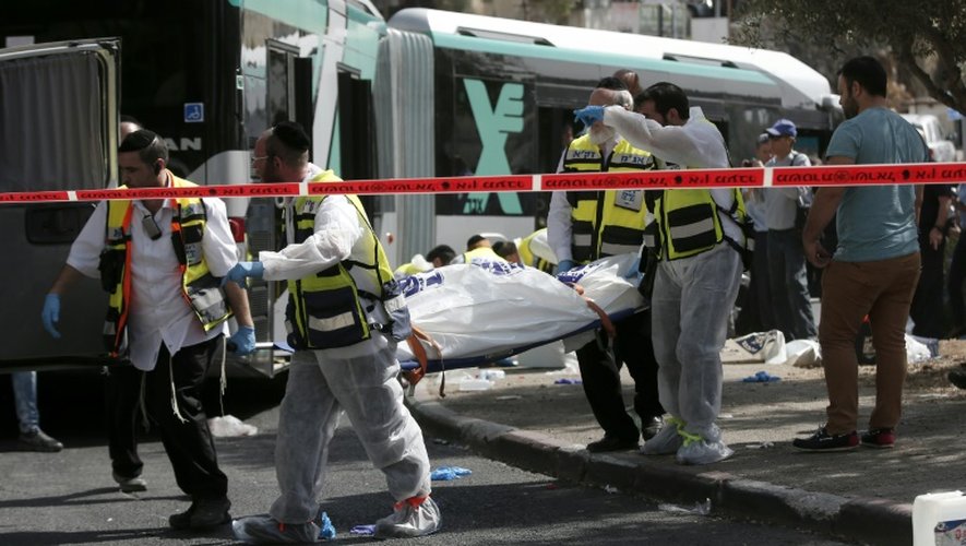 Des bénévoles du Zaka transportent un homme blessé dans un autobus à Jérusalem où un homme a ouvert le feu sur les passagers, le 13 octobre 2015