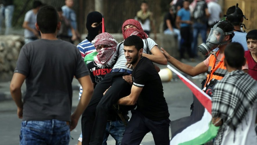 Des manifestants palestiniens transportent un blessé, le 13 octobre 2015 à Bethléem, en Cisjordanie