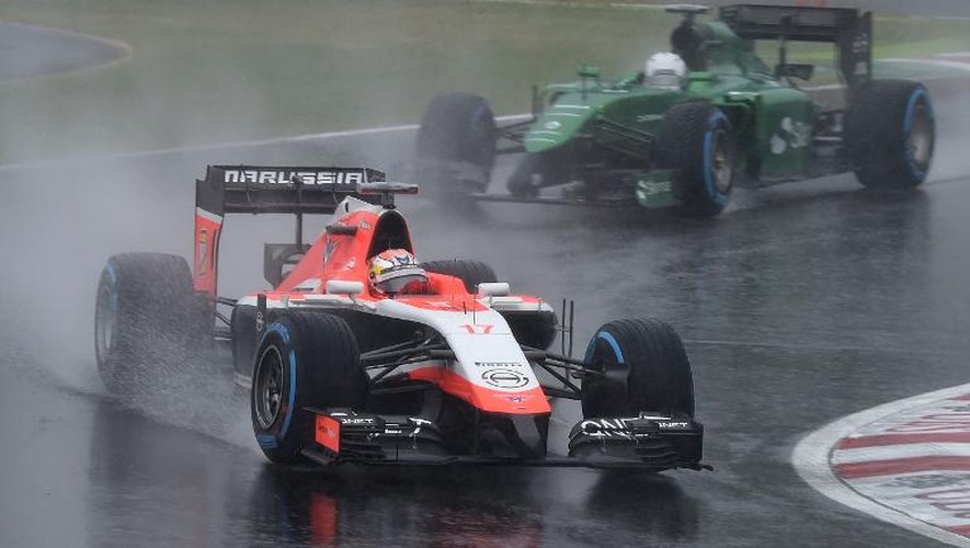 Jules Bianchi (g) au volant de sa Marussia avant son terrible accident sur la piste détrempée du circuit de Suzuka au Grand Prix du Japon, le 5 octobre 2014
