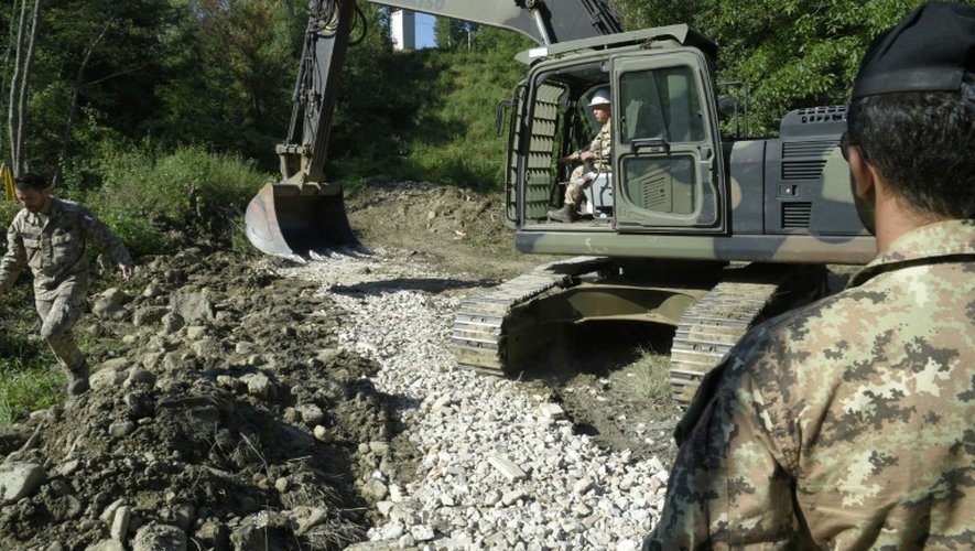 Des soldats italiens utilisent une pelleteuse pour créer une nouvelle route près d'Amatrice et pour acheminer les secours, le 28 août 2016, quatre jours après le violent séisme