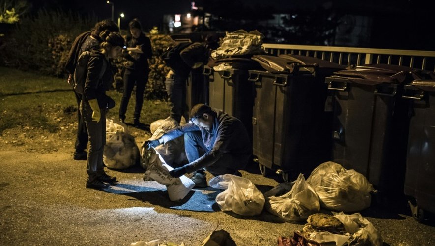 Des membres du mouvement les "Gars'pilleurs" fouillent les poubelles d'un supermarché au sud de Lyon, le 24 septembre 2015