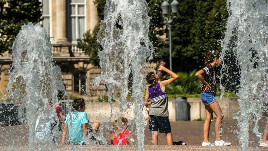 Des personnes se rafraîchissent sous les fontaines, le 24 août 2016 à Lille
