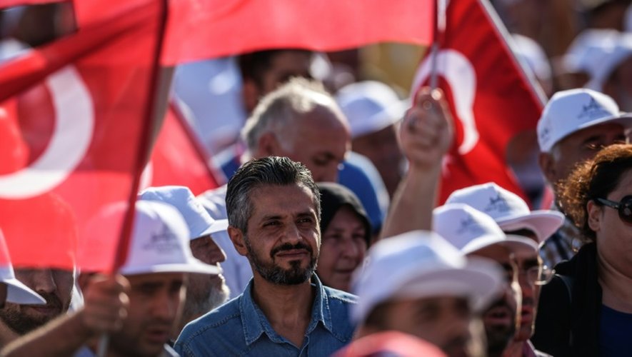 Des Turcs brandissent des drapeaux nationaux lors de l'inauguration du pont Yavuz Sultan Selim, le 26 août 2016 à Istanbul