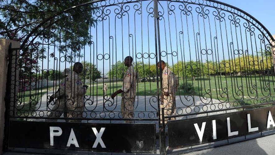 Des policiers haïtiens gardent le portail d'entrée de la morgue de Pax Villa à Port-au-Prince où est conservé le corps de l'ex-dictateur Jean-Claude Duvalier, le 4 octobre 2014