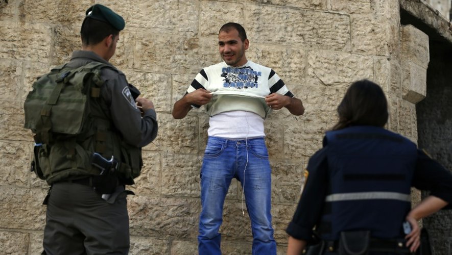Un jeune Palestinien est contrôlé par des policiers israéliens porte de Damas, à l'entrée de la vieille ville à Jérusalem-Est, le 13 octobre 2015