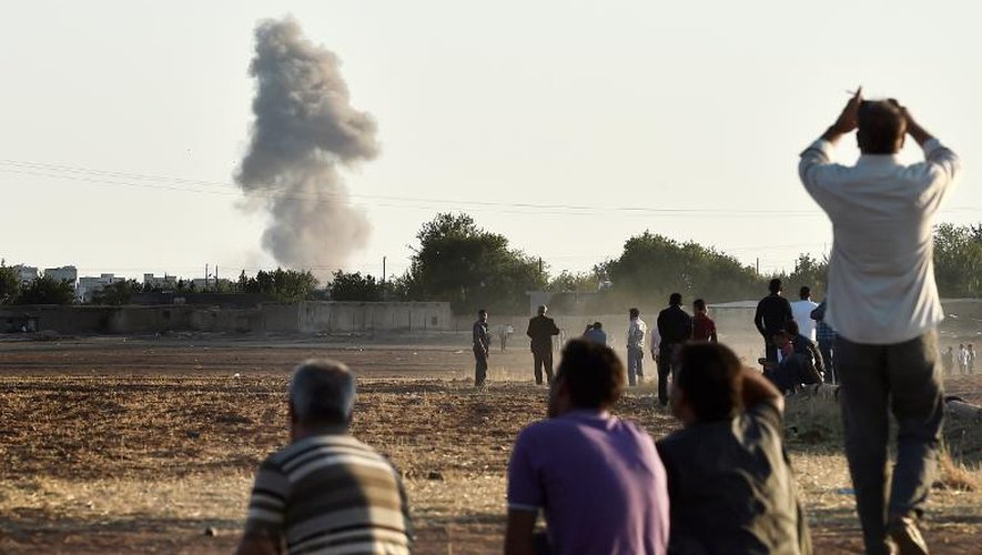 Des Kurdes regardent les frappes aériennes de la coalition sur Kobané, le 7 octobre 2014 en Syrie