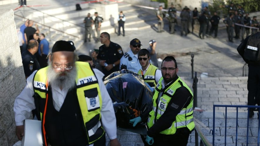 Des bénévoles ZAKA israéliens portent le corps d'un homme qui a tenté de commettre une attaque au couteau, près de la porte de Damas à l'est de Jérusalem, le 14 octobre 2015