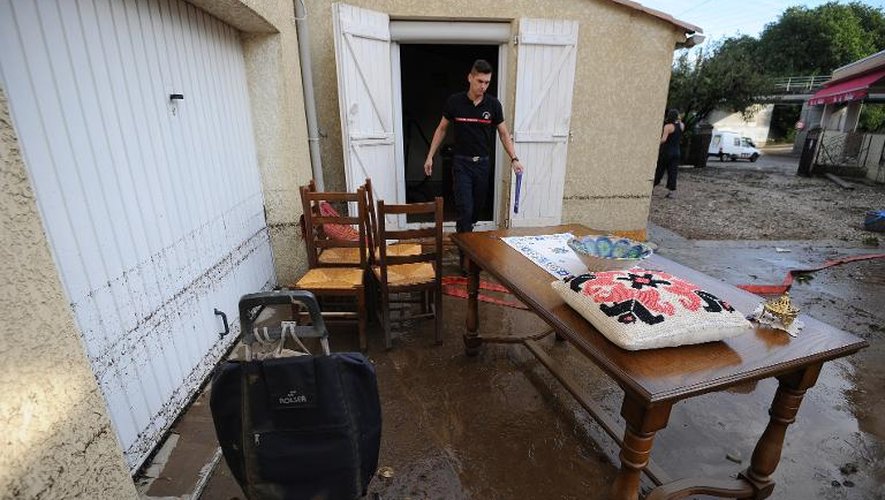 Un pompier déplace des meubles d'une maison touchée par les inondations à Alès, le 20 septembre 2014