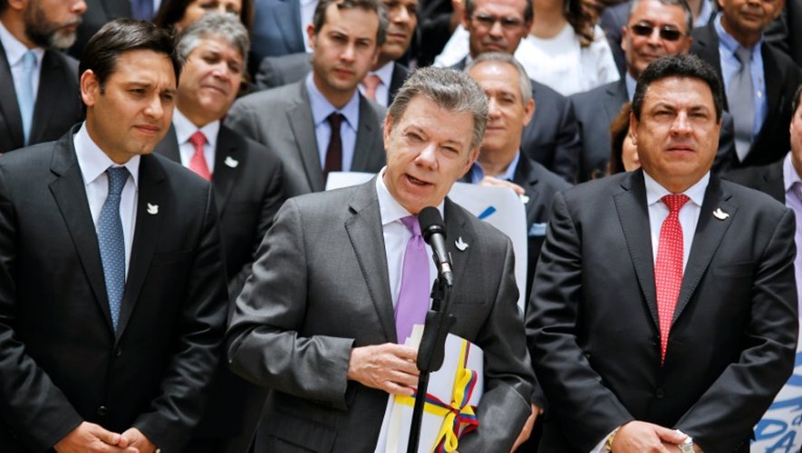 Le président colombien Juan Manuel Santos le 25 août 2016 à Bogota, avec une copie de l'accord de paix avec les FARC