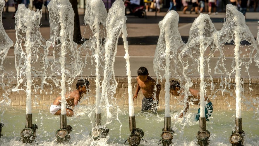 Des enfants se rafraîchissent dans une fontaine à lille le 27 août 2016