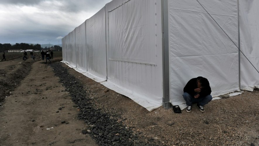 Un homme assis devant une tente d'un camp de migrants près de la  frontière entre la Grèce et la Macédoine à Idomeni, le 14 octobre 2015