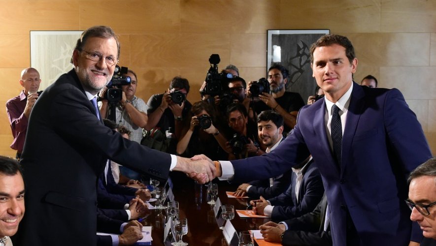 Le Premier ministre espagnol  Mariano Rajoy (g) et le responsable de Ciudadanos Albert Rivera, se serrent les mains à Madrid, le 28 août 2016