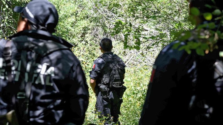 Des policiers mexicains près d'une fosse commune découverte il y a quelques jours près d'Iguala, le 9 octobre 2014 dans l'Etat de Guerrero