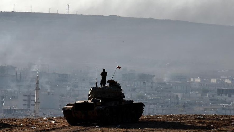 Un soldat turc debout sur un char regarde la ville de Kobané depuis une colline à Mursitpinar, le 9 octobre 2014