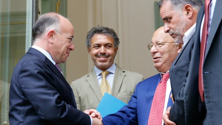 Le ministre de l'Intérieur Bernard Cazeneuve (G) sert la main du recteur de la mosquée de Paris Dalil Boubaker le 29 août 2016 à Paris