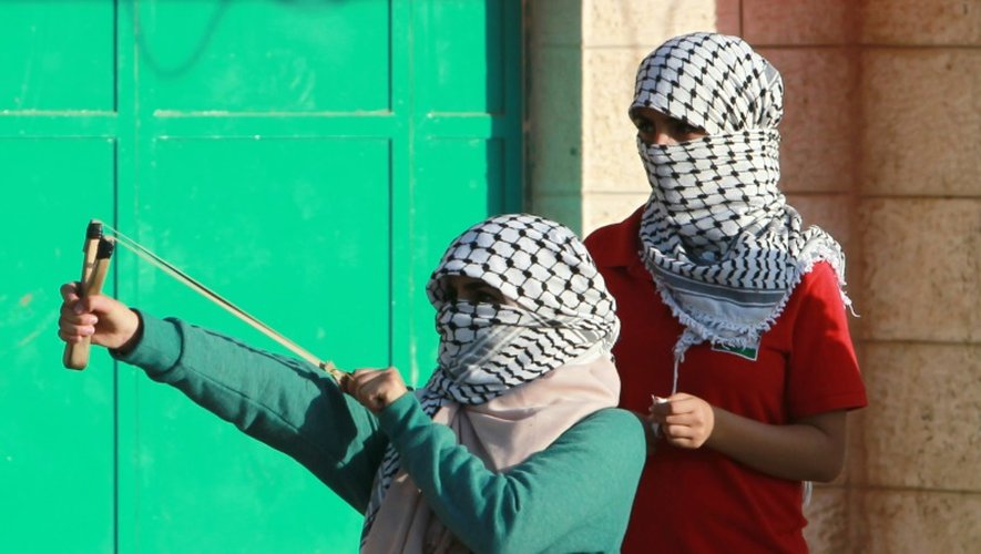 Des Palestiniennes masquées lancent des pierre conre les forces de sécurité israéliennes le 15 octoobre 2015 à Betlehem
