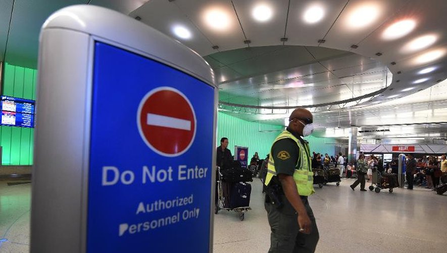 Un employé de l'aéroport de Los Angeles porte un masque le 9 octobre 2014, après l'annonce par Washington d'un renforcement du contrôle des voyageurs en provenance des pays africains touchés par Ebola