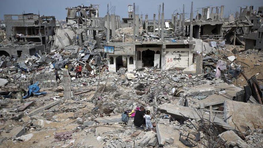 Des Palestiniens au milieu d'immeubles détruits à Al-Tufah, le 11 octobre 2014 dans la bande de Gaza, à la veille d'une conférence de donateurs pour sa reconstruction