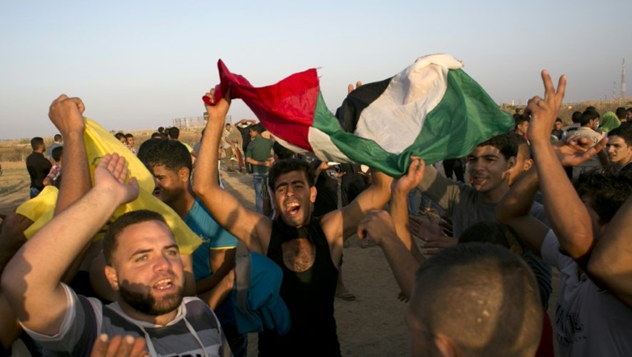 Des Palestiniens crient leur colère face à des soldats israéliens à la frontière entre Gaza et Israël le 16 octobre 2015