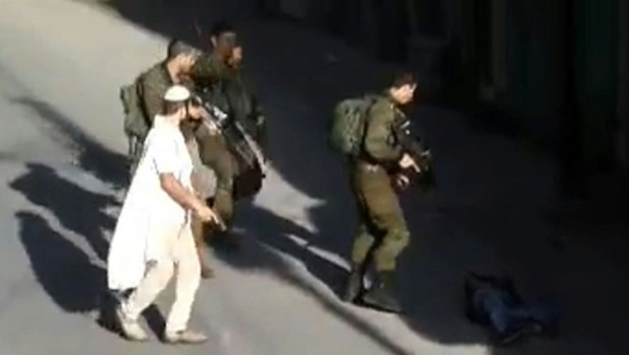 Capture d'écran d'une vidéo fournie par le groupe pacifiste Youth Against Settlements, le 17 octobre 2015, de soldats israéliens à côté du corps d'un Palestinien ayant tenté d'attaquer un colon israélien à Hébron