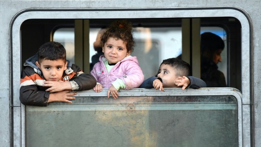 Des enfants de migrants attendent dans un train à l'arrêt en gare de Cakovec, dans l'ouest de la Croatie, de pouvoir continuer leur périple en car, le 17 octobre 2015
