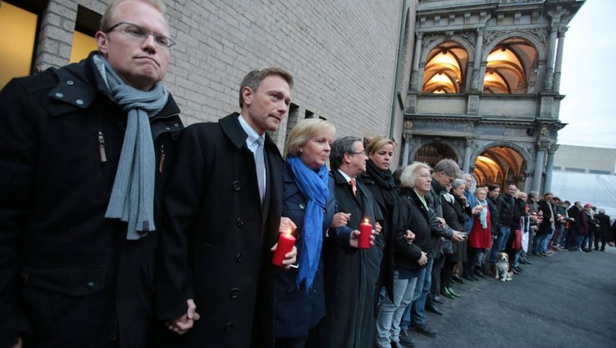 De g à d: des responsables politiques allemands de tous bords forment une chaîne humaine "contre la violence" devant l'hôtel de ville de Cologne, en Allemagne, le 17 octobre 2015