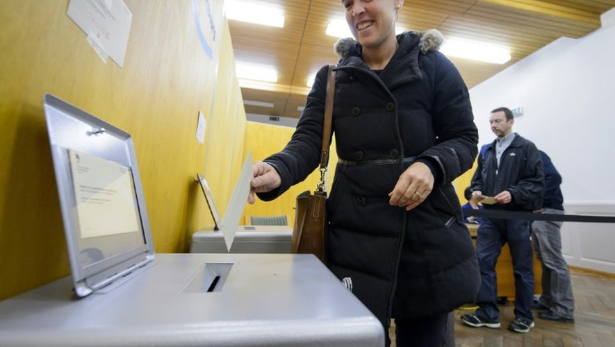 Une femme dépose son vote, le 18 octobre 2015 à Fribourg, dans l'ouest de la Suisse, pour les élections législatives