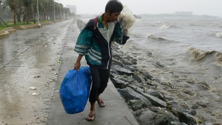 Un homme lutte contre les vents violents et les trombes de pluie qui accompagnent l'arrivée du typhon Koppu à Manille, le 18 octobre 2015