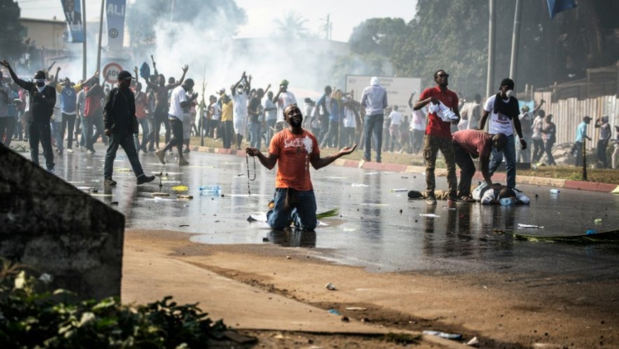Un partisan de l'opposition gabonaise prie devant les forces de l'ordre à Libreville lors d'une manifestation contre la réélection d'Ali Bongo, le 31 août 2016