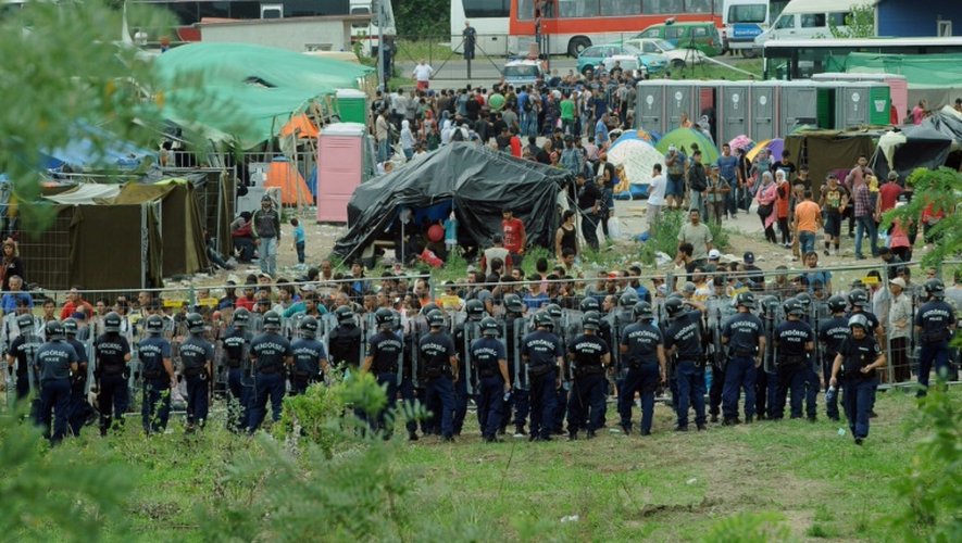 Des policiers hongrois entourent un camp de réfugié à Röszke, le 4 septembre 2015 à la frontière serbe
