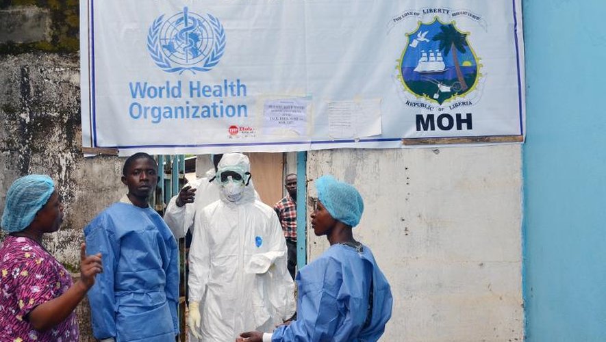 Des personnels de santé devant le centre de traitement des malades d'Ebola au John F. Kennedy Medical Center de Monrovia, le 13 octobre 2014