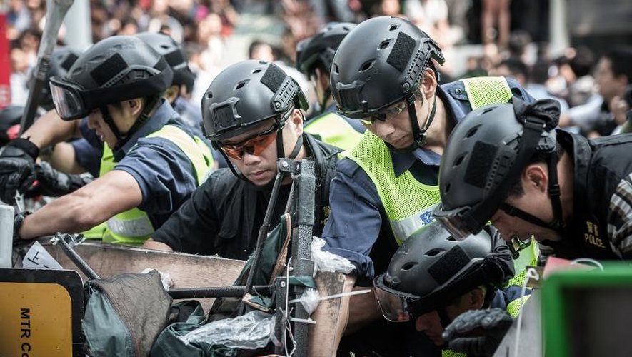 Des policiers démontent des barricades le 14 octobre 2014 à Hong Kong