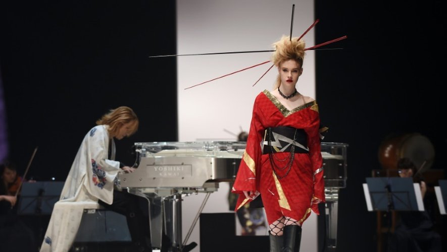 Une mannequin présente une création du musicien et couturier japonais Yoshiki (g, au piano) lors de la présentation de la première collection YOSHIKIMONO, le 17 octobre 2015 à Tokyo