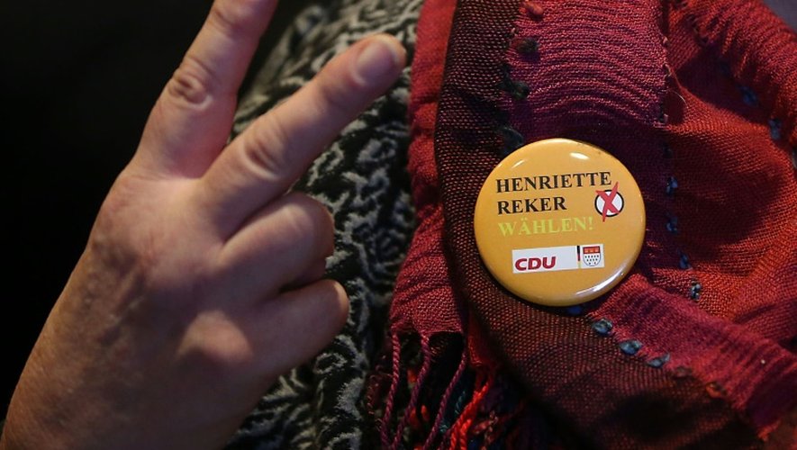 Un supporteur de la candidate à la mairie de Cologne Henriette Reker fait le V de la victoire après de premiers résultats en faveur de Mme Reker