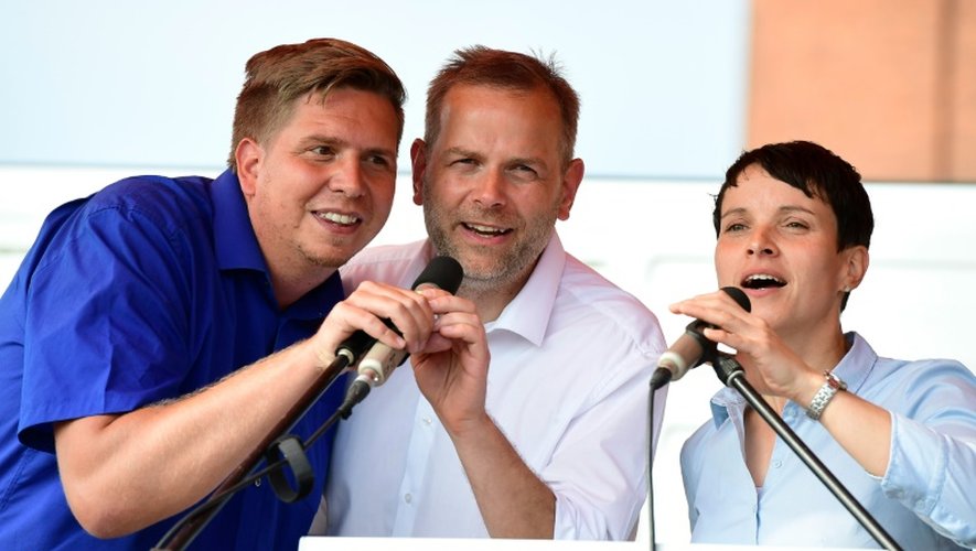 Leif-Erik Holm (c), candidat local de l'AfD aux élections régionales, la  présidente de l'AfD Frauke Petry (d) et Lars Loewe, un membre du parti (g) chantent l'hymne national, le 27 août 2016 à Wismar