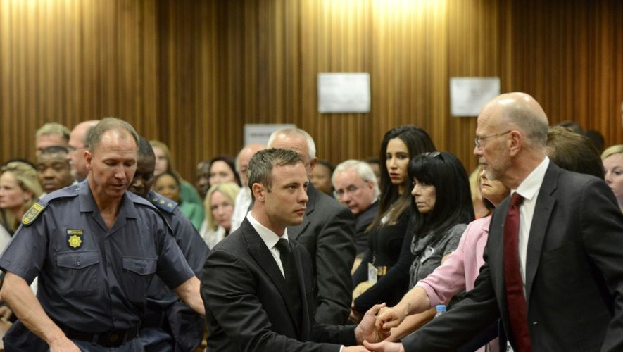 Oscar Pistorius serre la main de son oncle Arnold Pistorius avant d'être emmené en prison à l'issue de son procès le 21 octobre 2014 à Pretoria