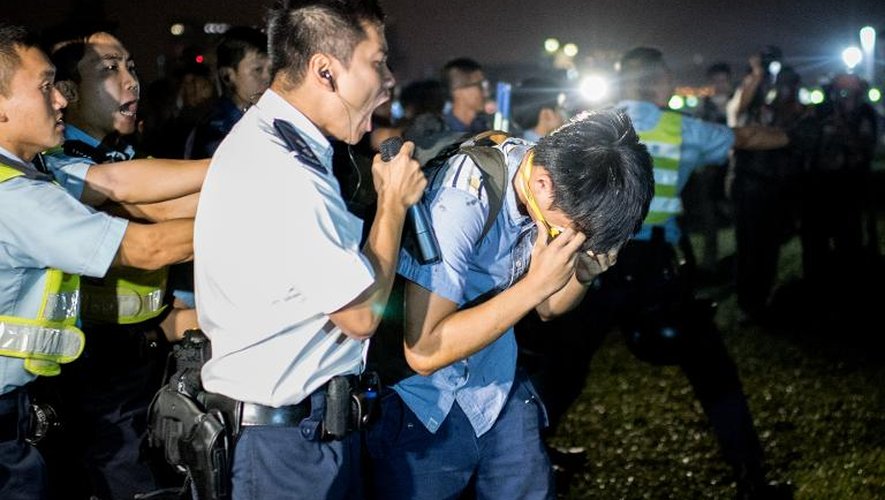 Un officier de police crie sur un manifestant aspergé de gaz au poivre à Hong Kong le 15 octobre 2014