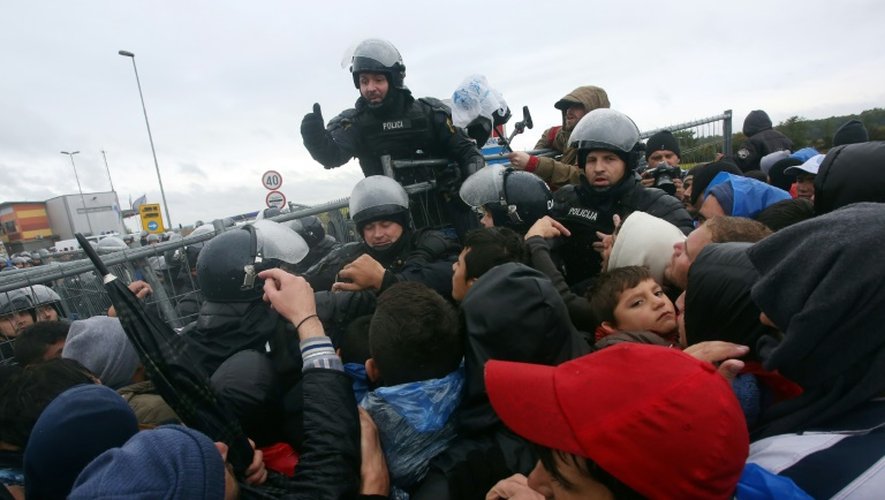 Des policiers face aux migrants qui affluent le 19 octobre 2015 à Trnovec à la frontière de la Slovénie et de la Croatie