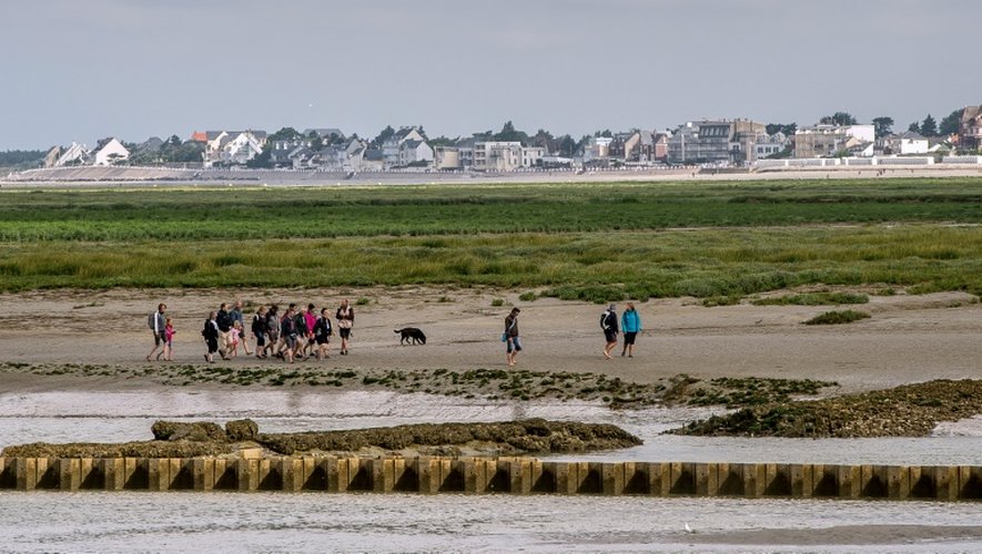 Des gens marchent sur le sable à Saint-Valery-sur-Somme dans la baie de Somme le 5 août 2016