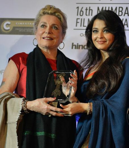 Catherine Deneuve, aux côtés de l'actrice indienne Aishwarya Rai (d), montre le prix reçu pour l'ensemble de sa carrière au 16e festival du film de Bombay, le 14 octobre 2014 en Inde