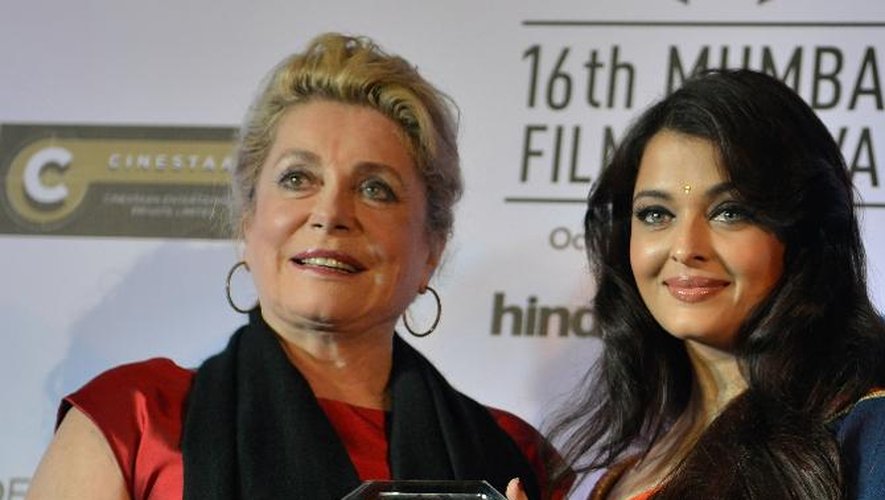 Catherine Deneuve, aux côtés de l'actrice indienne Aishwarya Rai (d), montre le prix reçu pour l'ensemble de sa carrière au 16e festival du film de Bombay, le 14 octobre 2014 en Inde