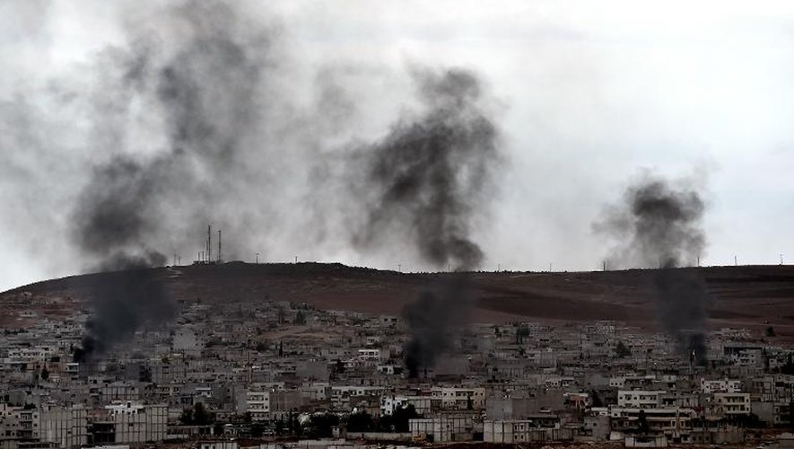 De la fumée s'élève de certaines parties de la ville syrienne de Kobané où les forces kurdes combattent les jihadistes de l'EI, le 16 octobre 2014