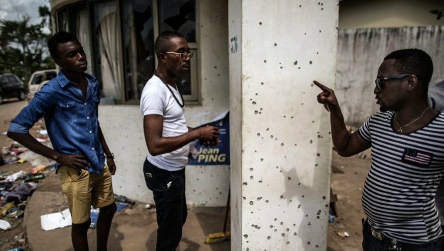 Un homme montre des impacts de balles au siège du QG de l'opposant Jean Ping, le 3 septembre 2016 à Libreville