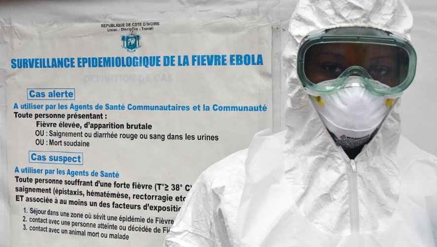 Un travailleur de santé pose devant des instructions concernant Ebola à l'hôpital de Yopougon en Côte d'Ivoire le 17 octobre 2014