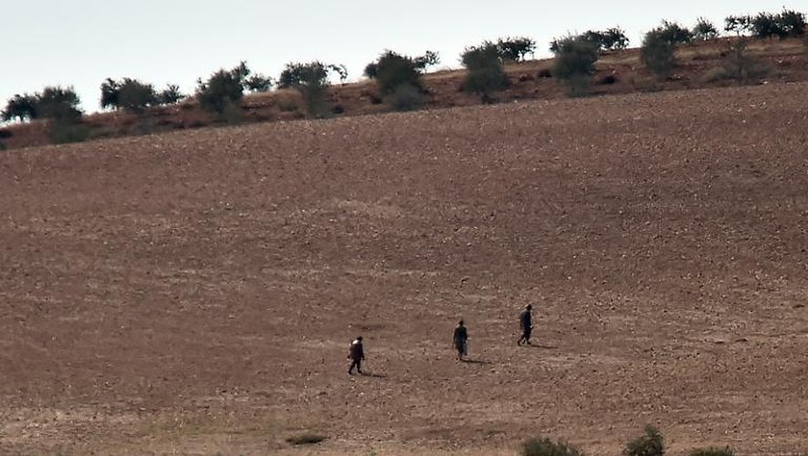 Des membres présumés du groupe Etat islamique sur une colline à l'ouest de Kobané, en Syrie le 18 octobre 2014