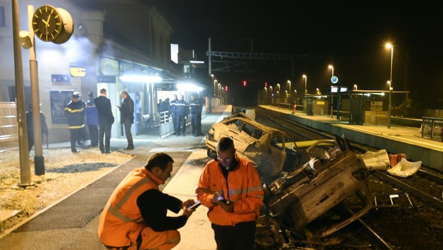 Des agents SNCF et la police près de voitures calcinées sur les voies ferrées devant la gare de Moirans, le 20 octobre 2015