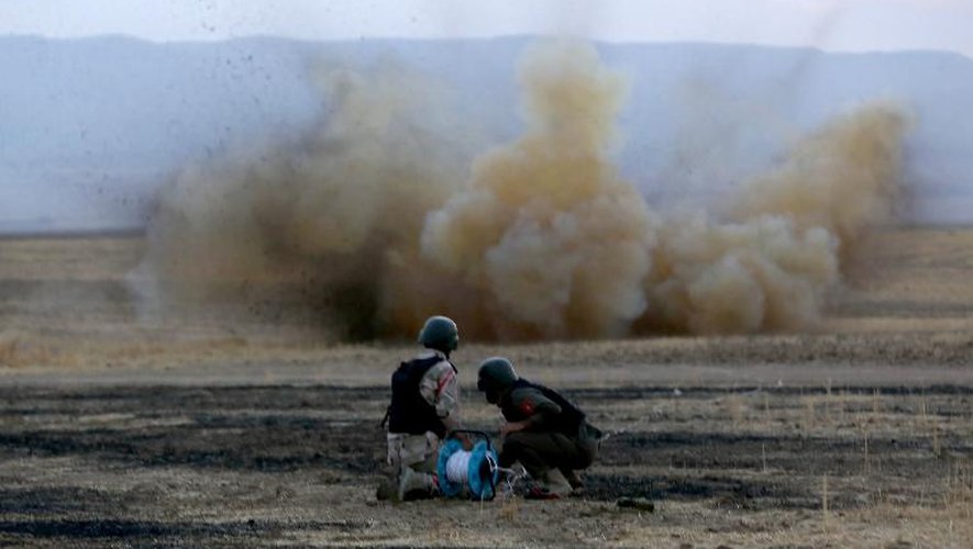 Des Kurdes Peshmergas désamorcent une mine posée par le groupe Etat islamique près d'Arbil le 18 octobre 2014