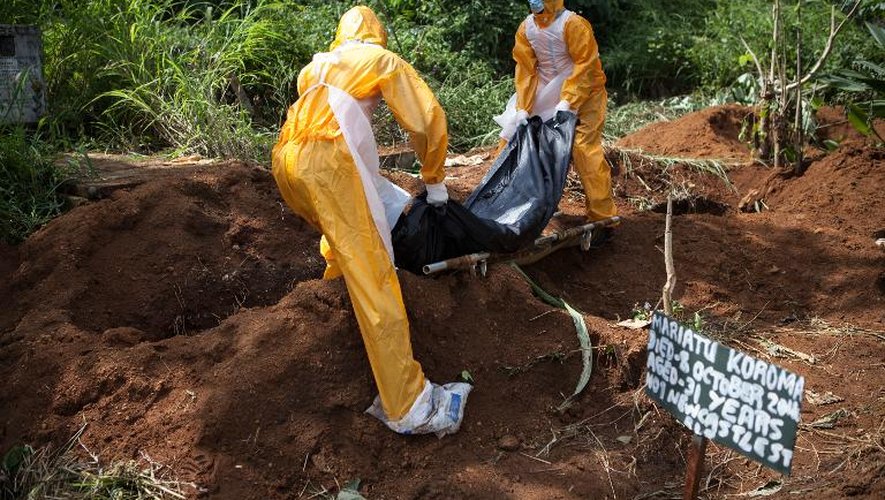 Une équipe d'employés des pompes funèbres spécialisés enterrent une victime d'Ebola à Freetown le 10 octobre 2014