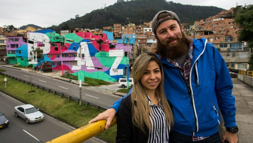 Spag, un des auteurs français de la fresque pose devant l'oeuvre de streetart réalisée sur les façades de maisons du quartier pauvre de Mariscal Sucre, à Bogota le 1er septembre 2016